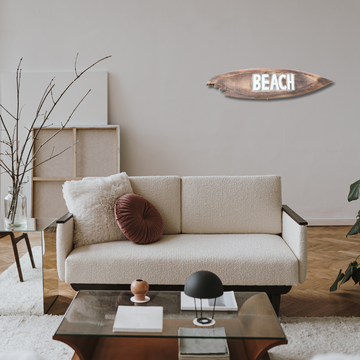 Modern living room with a beige sofa, decorative pillows, and a glass coffee table.