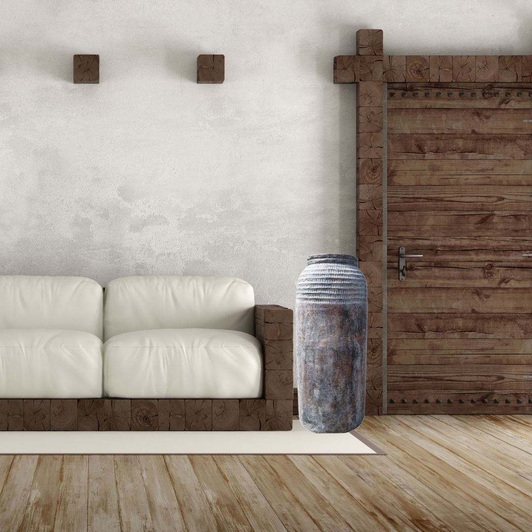 Tall rustic textured floor vase styled beside a white sofa and reclaimed timber barn door in a farmhouse living room | Azure Decor