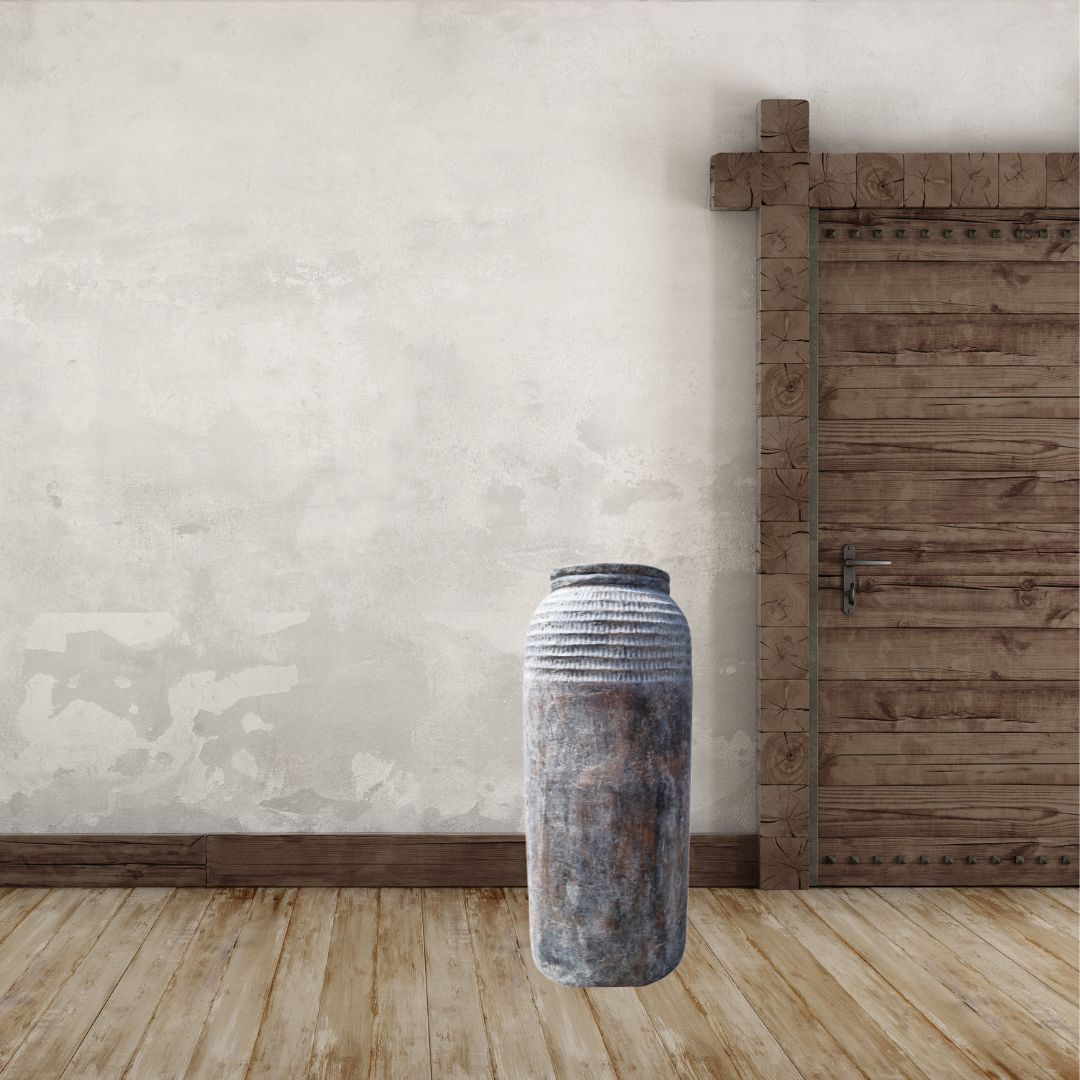 Tall rustic textured floor vase with dried bamboo on timber herringbone floor against concrete wall | Azure Decor