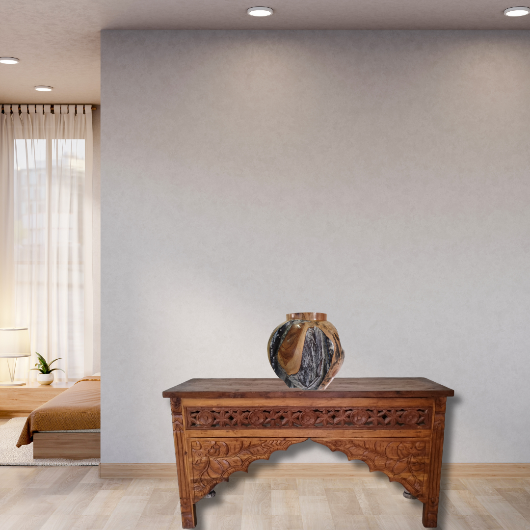Wooden table with a vase on it in a room with a bed and window.