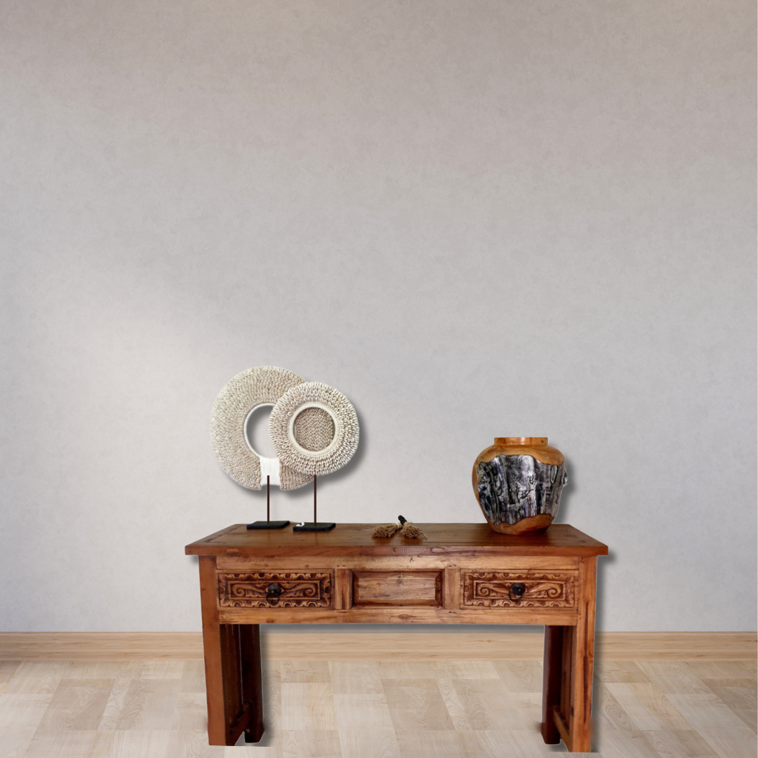 Wooden console table with decorative items against a plain wall