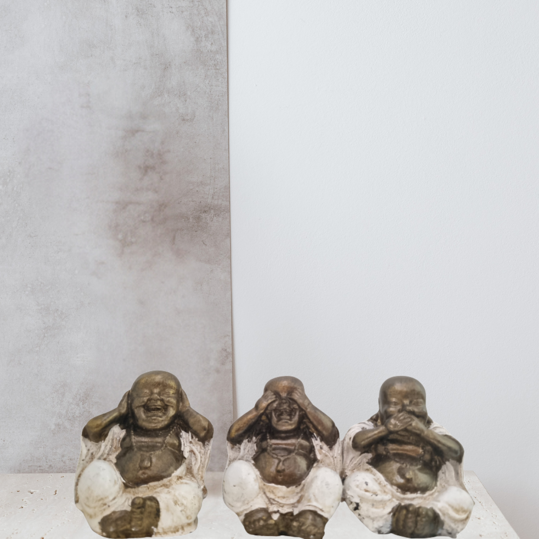 Three small Buddha statues in a row against a plain background