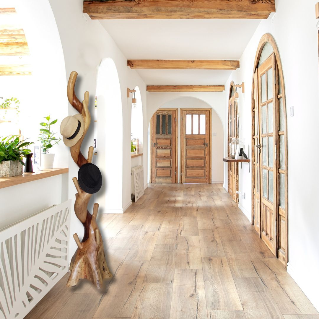 Hallway with wooden flooring, white walls, and a coat rack with hats.