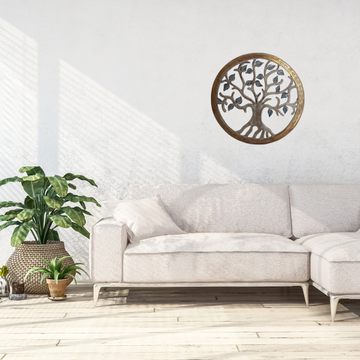 Decorative  wall art of a tree on a white wall above a gray sofa.