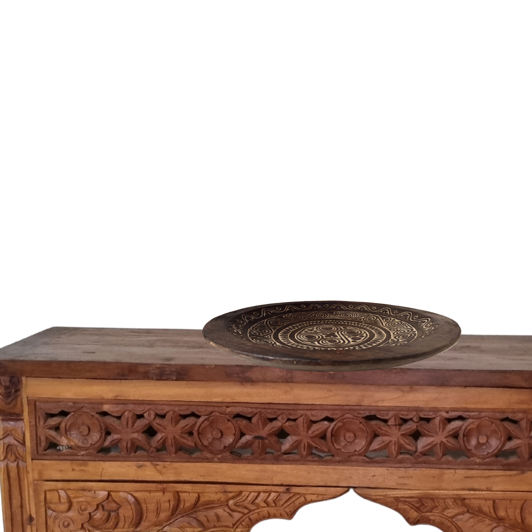 Carved wooden console table with a decorative plate on a white background