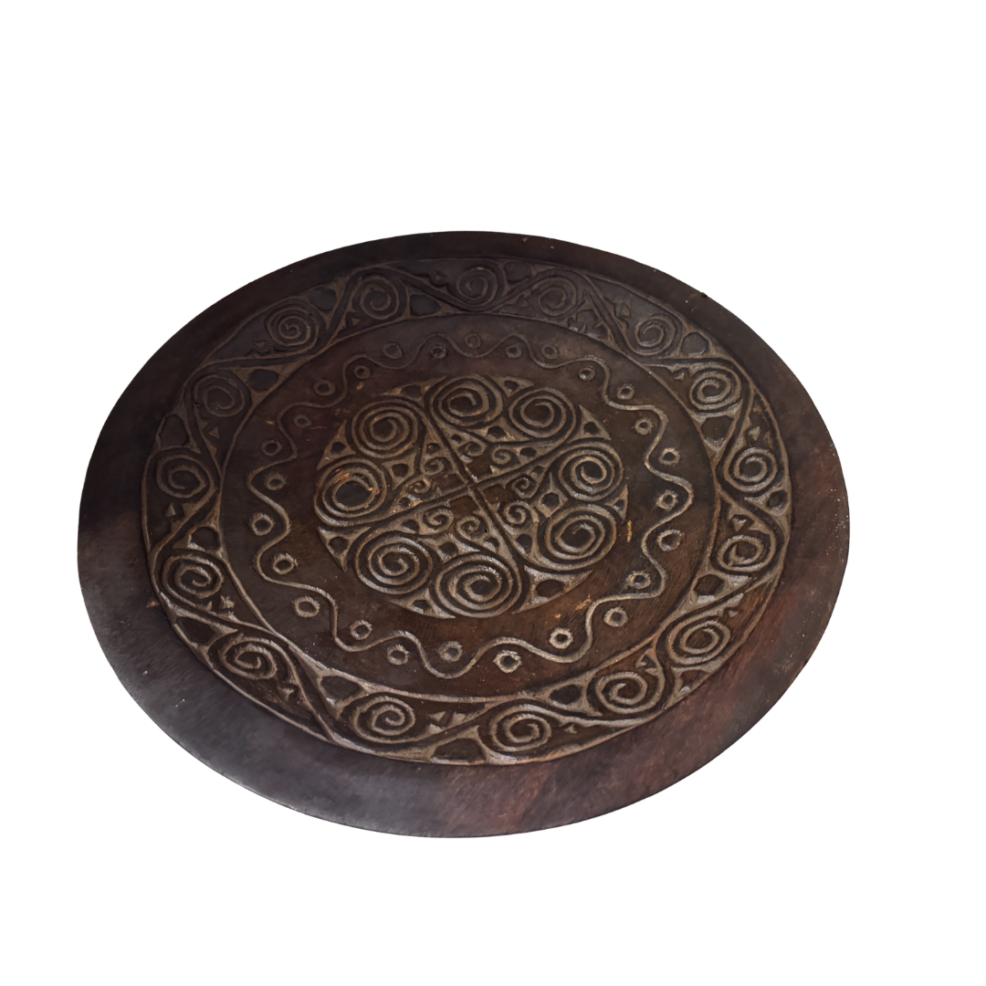 Wooden plate with intricate carvings on a white background