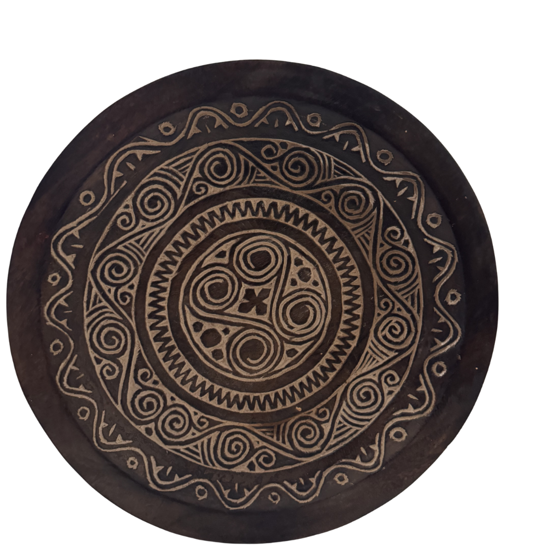 Decorative wooden plate with intricate circular patterns on a white background