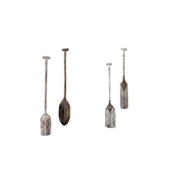 A selection of four tribal carved wooden paddles in different sizes, with a brown wash finish, displayed against a white background.