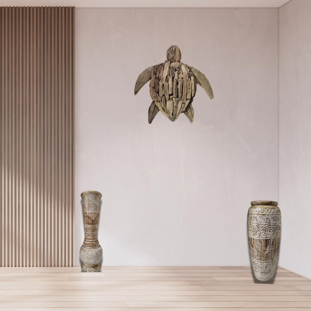 Tribal Harmony teak wood vases styled together in a modern coastal hallway — baluster vase (left) and tapered cylinder vase (right) beside a timber slat wall panel, driftwood sea turtle wall art above, bleached timber floor