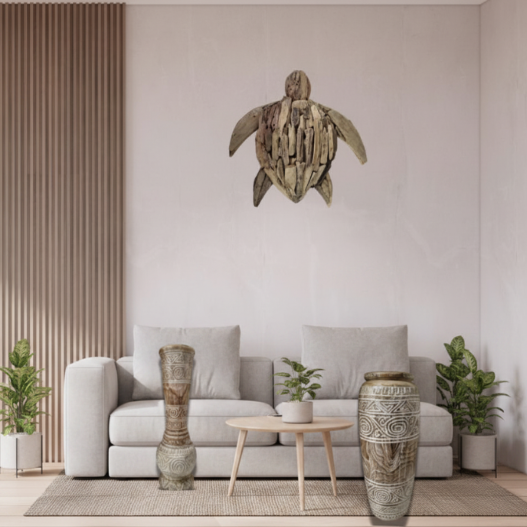 Tribal Harmony teak wood vases styled together in a modern coastal hallway — baluster vase (left) and tapered cylinder vase (right) beside a timber slat wall panel, driftwood sea turtle wall art above, bleached timber floor