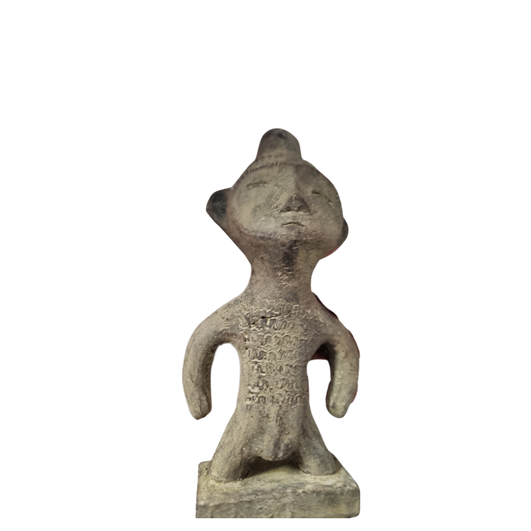 Tribal stone statue inspired by ancient Sulawesi figures displayed on white wall