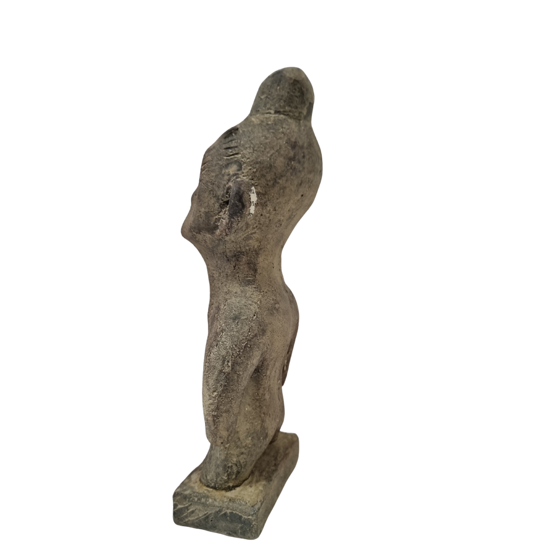 Tribal stone statue inspired by ancient Sulawesi figures white wall background