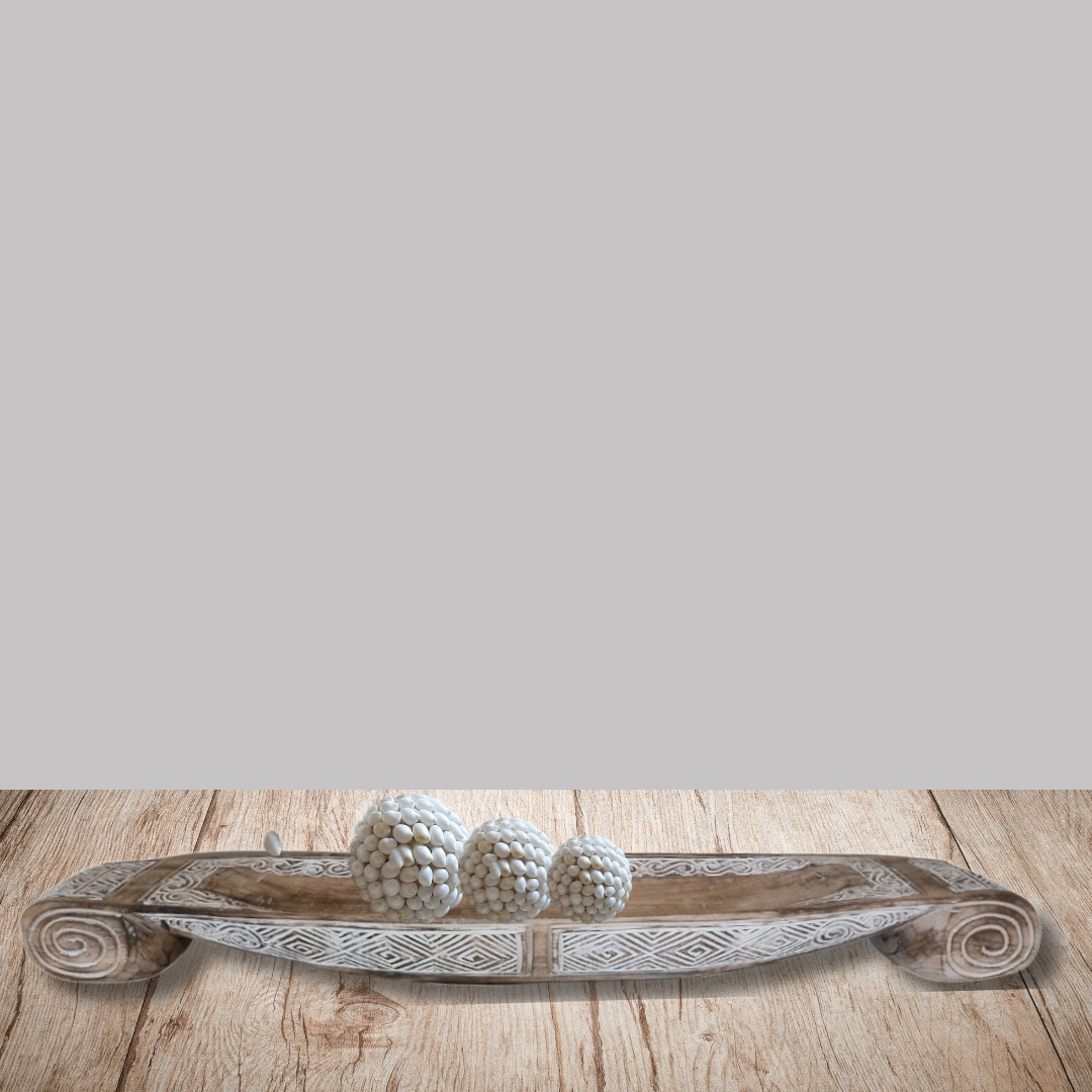 Decorative wooden tray with spherical decorative items on a wooden surface