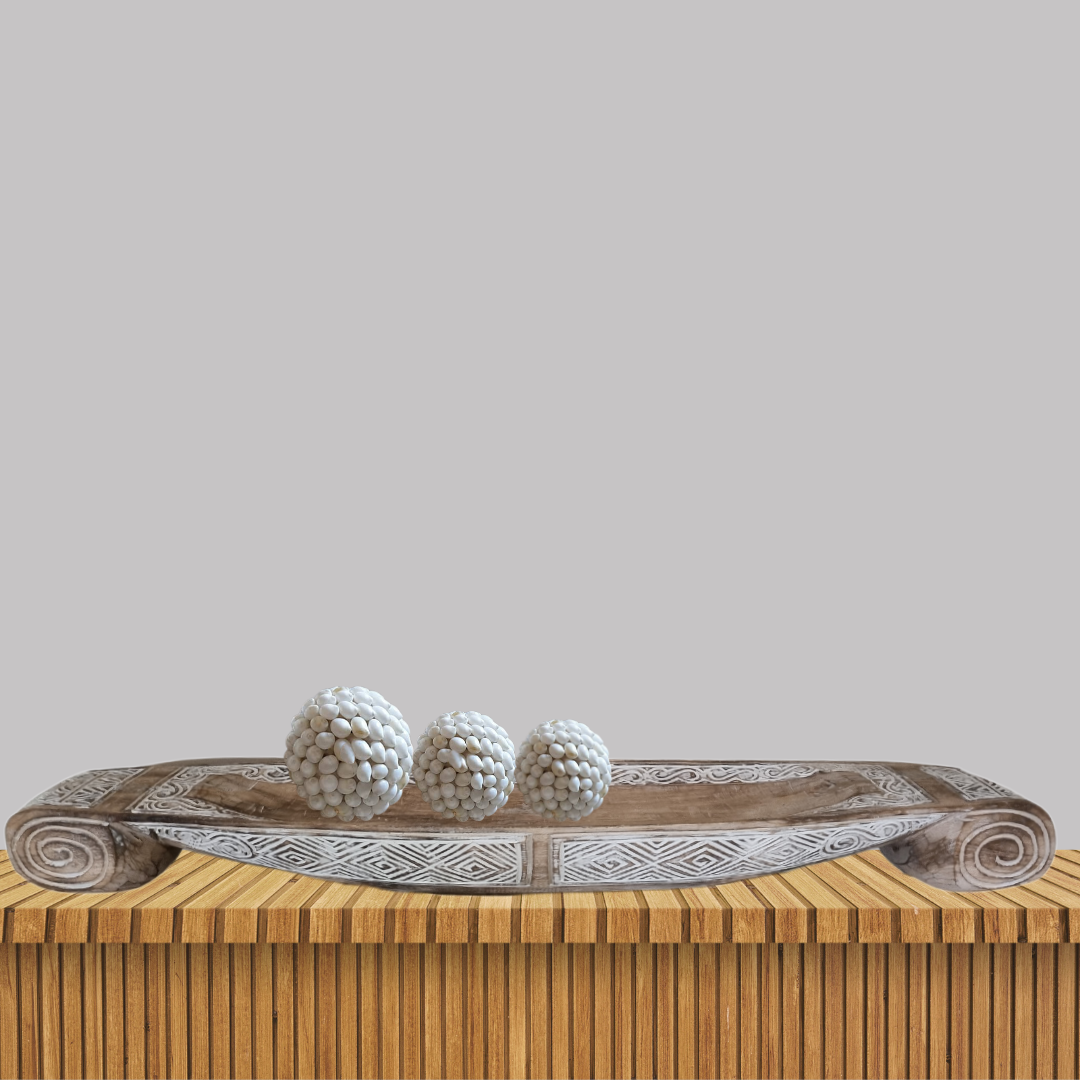 Decorative wooden tray with spherical decorative items on a wooden surface
