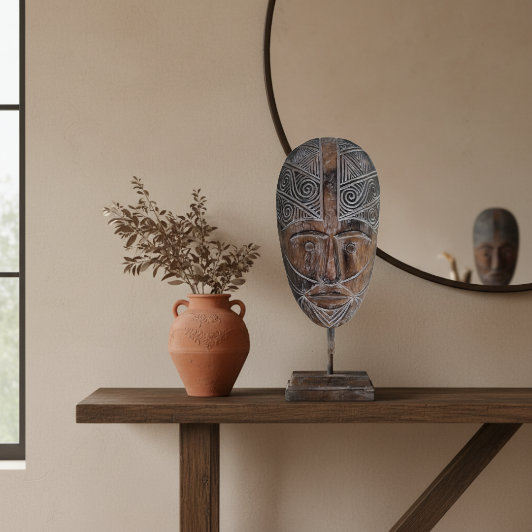 Brown carved décor displayed  with a mirror reflexion and a terricotta pot with branches 