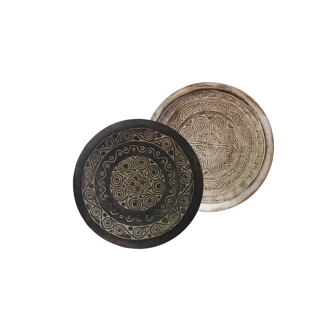 Two round wooden bowls-trays with intricate tribal style patterns on a white background