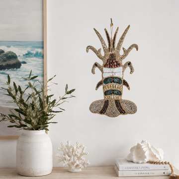 Tropical Lobster Shell Wall Decor — Handcrafted Natural Shell Art close up Shell wall sculpture on a white wall styled with an ocean seascape painting, white coral, conch shell and olive branches in a white vase
