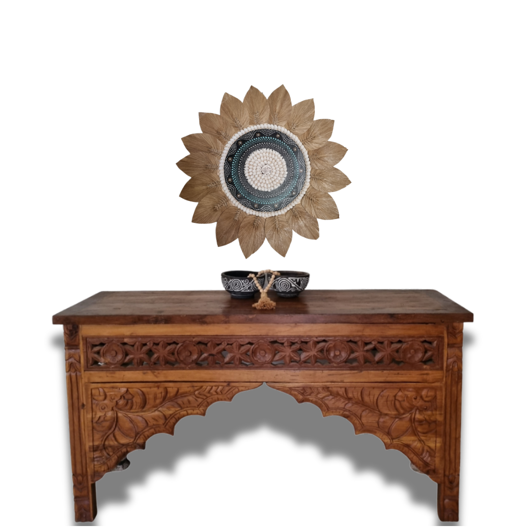 Seagrass and shell artpiece with Carved wooden table with decorative items on a white background