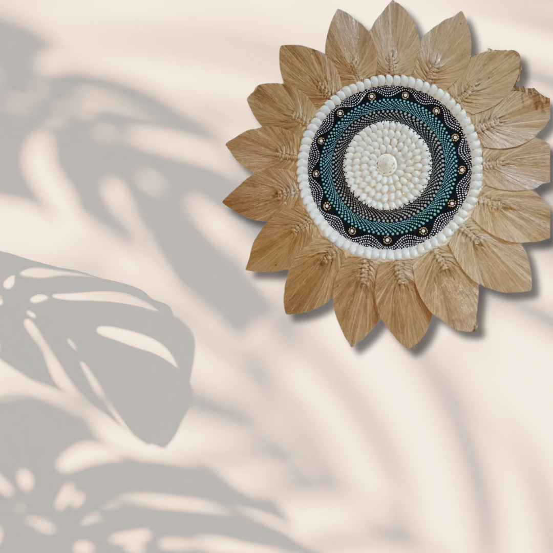 Tropical seagrass and shell wall art with painted centrepiece displayed on beige wall