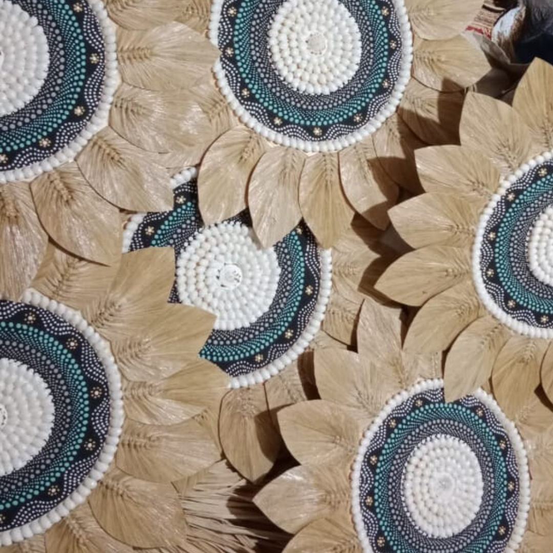 Multiple seagrass and shell wall decorations styled together in tropical coastal home décor