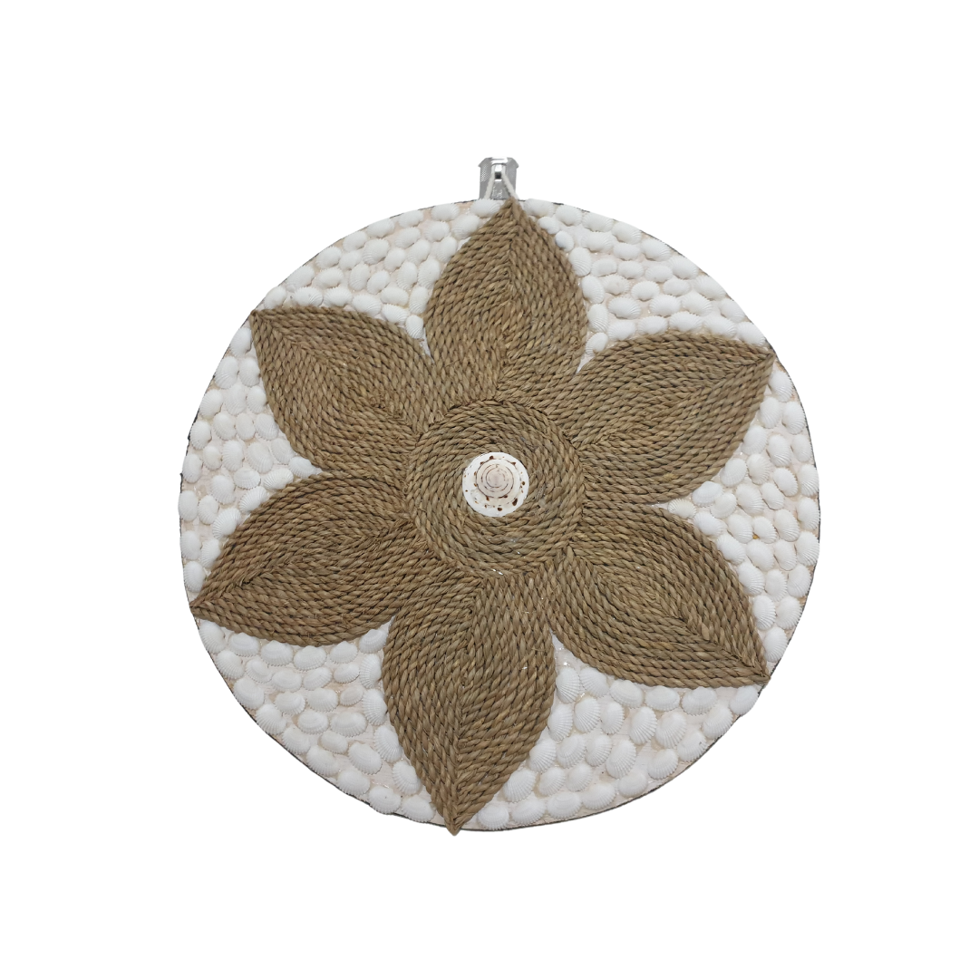 Round tropical wall decor piece — Style 2 with a bold tan jute star flower pattern and a central spiral shell accent on a white cowrie shell base.