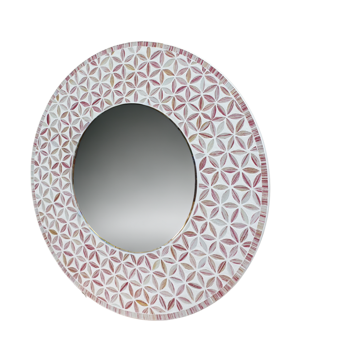 Oval mirror with a decorative pink and white patterned frame on a white background