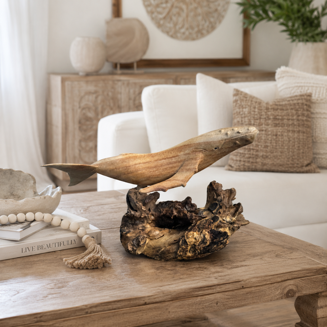 Whale Decor Wooden Designs sculpture on a natural driftwood base styled on a rustic timber coffee table in a coastal living room with white sofa and woven cushions