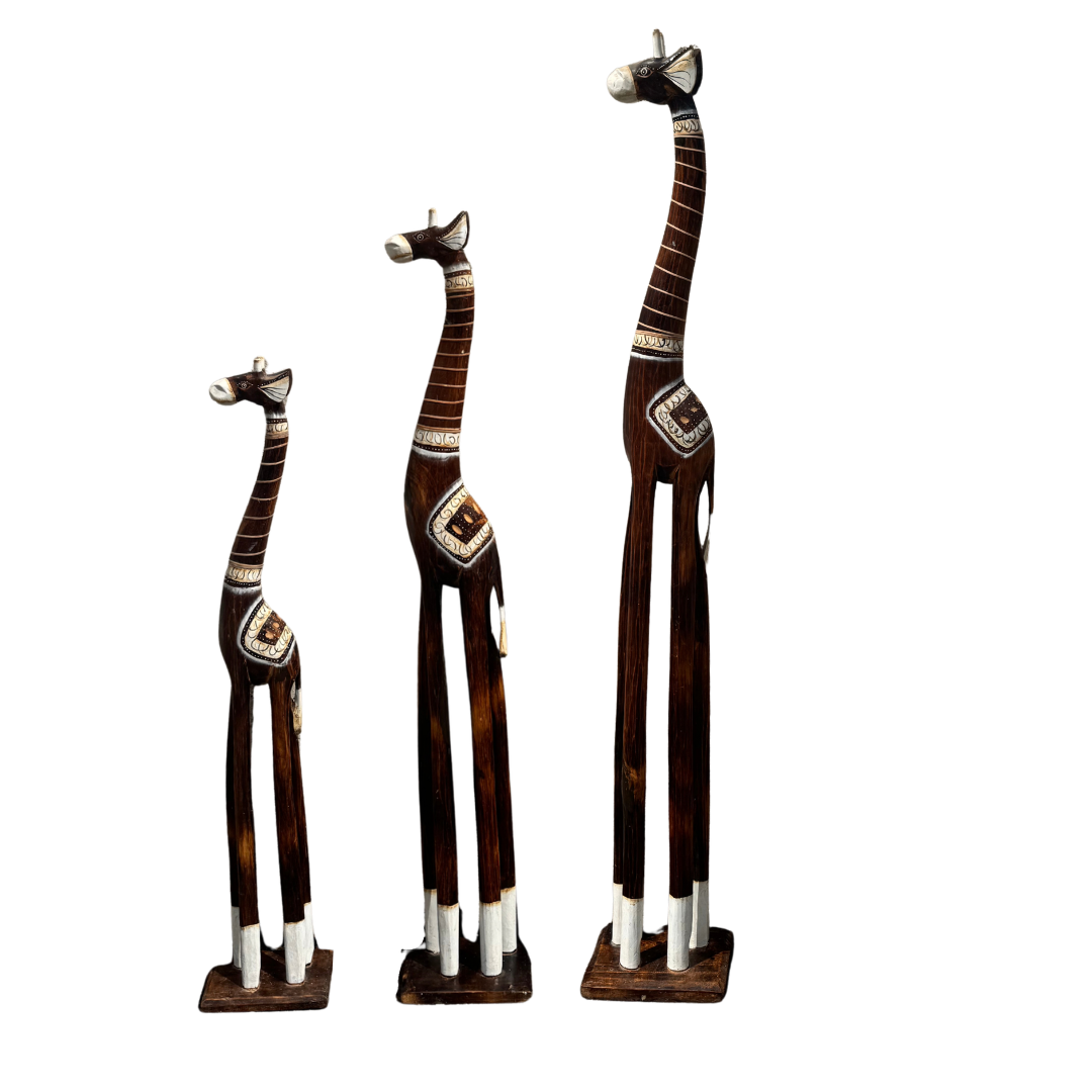 Three dark brown animal carvings with cream painted details arranged smallest to tallest on a white background