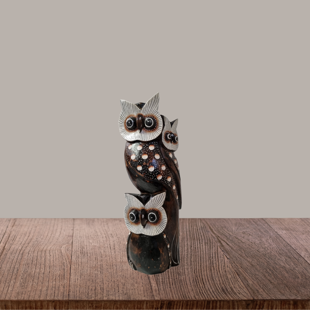 Decorative owl sculpture on a wooden surface with a plain background