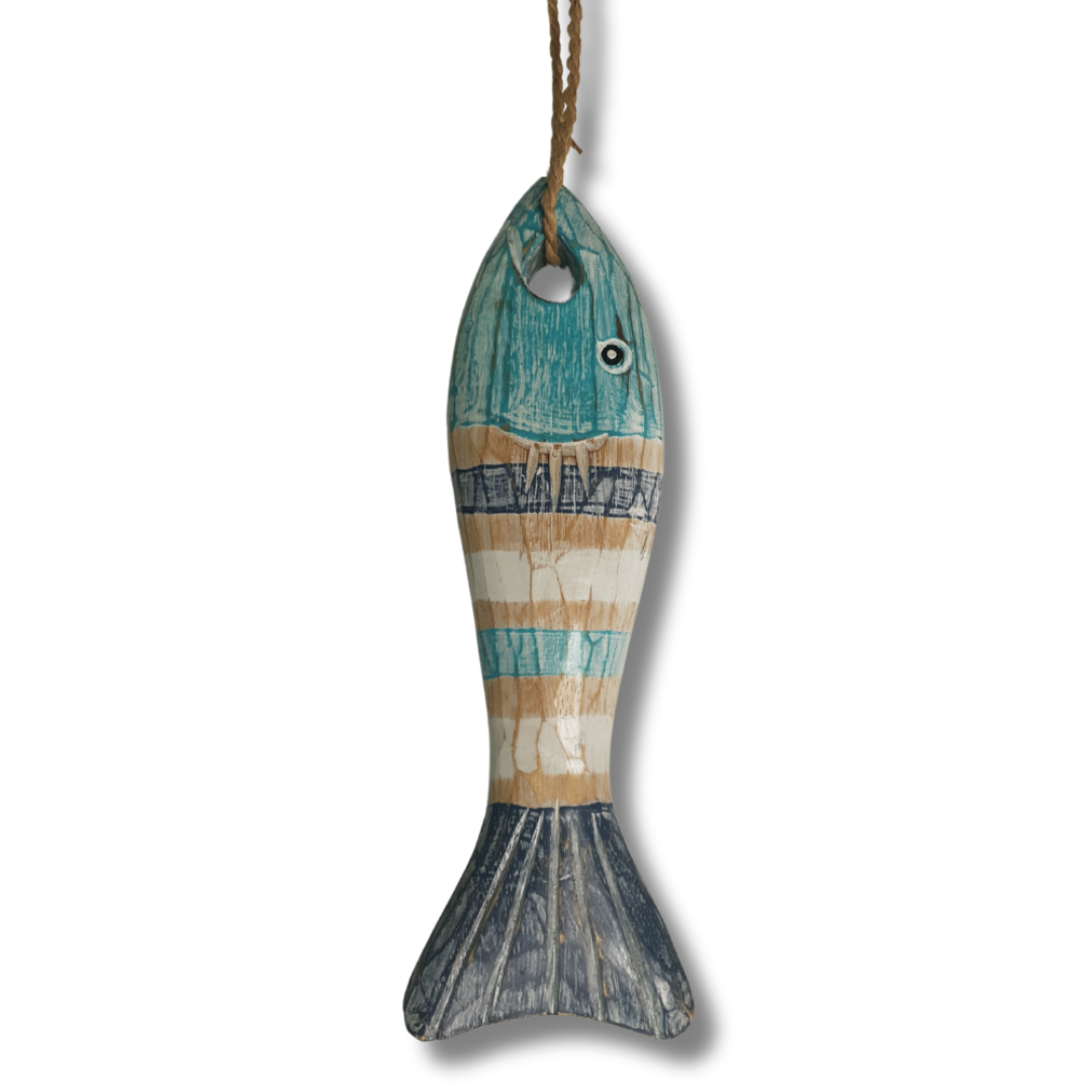 A rustic fish-shaped hanging ornament made from distressed wood, painted with horizontal stripes in teal blue, beige, and off-white, with a dark blue-gray fin and tail. It hangs from a brown string against a plain white background.