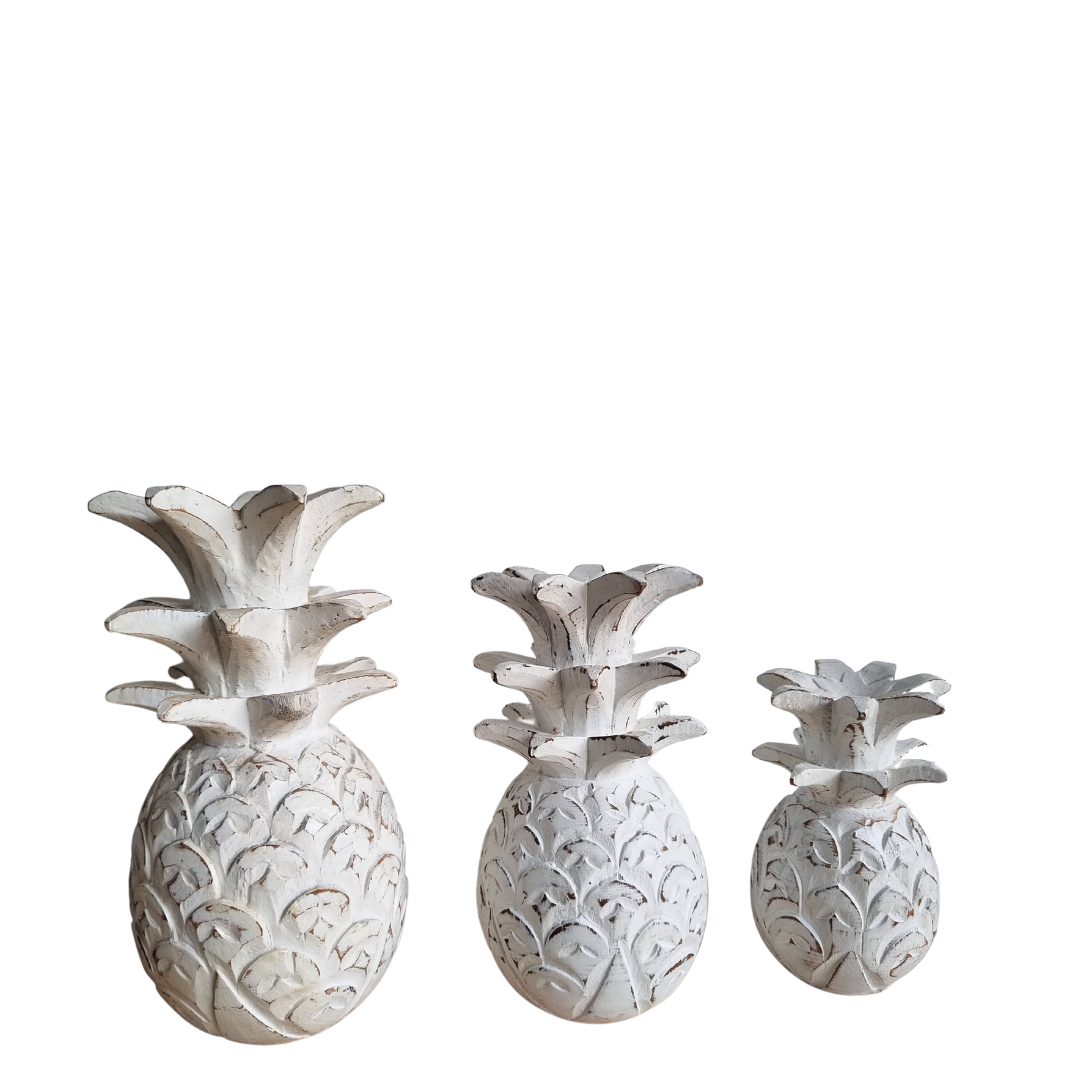 Set of three decorative pineapple figurines on a white background