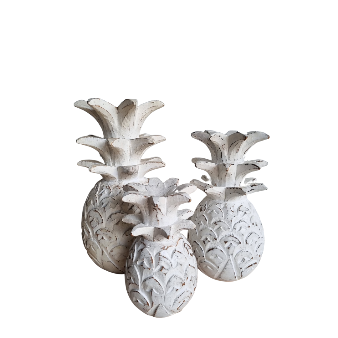 Decorative white pineapple sculptures on a white background