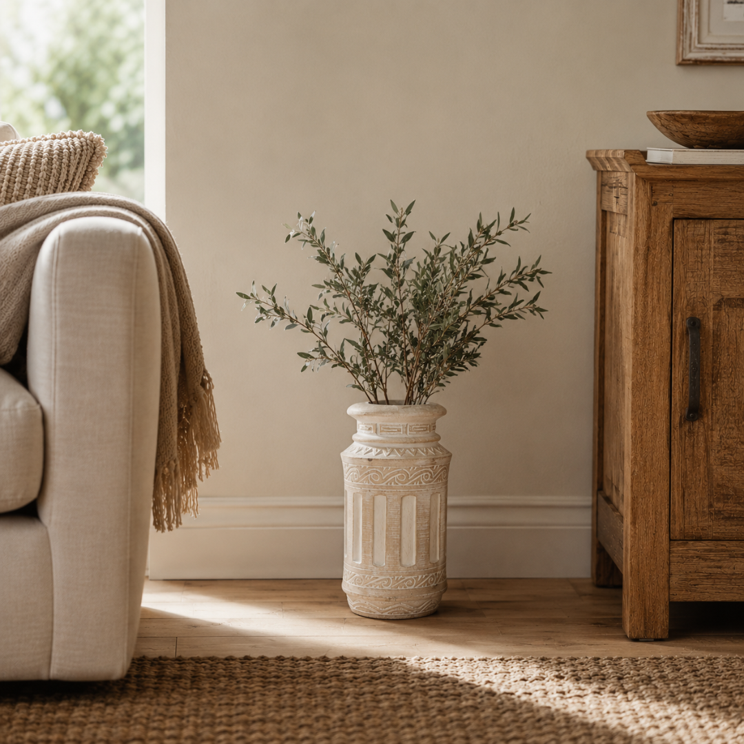 Living room with beige sofa, wooden cabinet, and decorative vase with greenery.