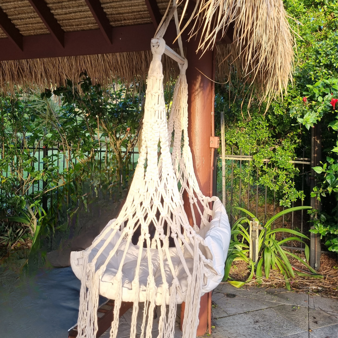 side view of the biege style hammock under a bali hut