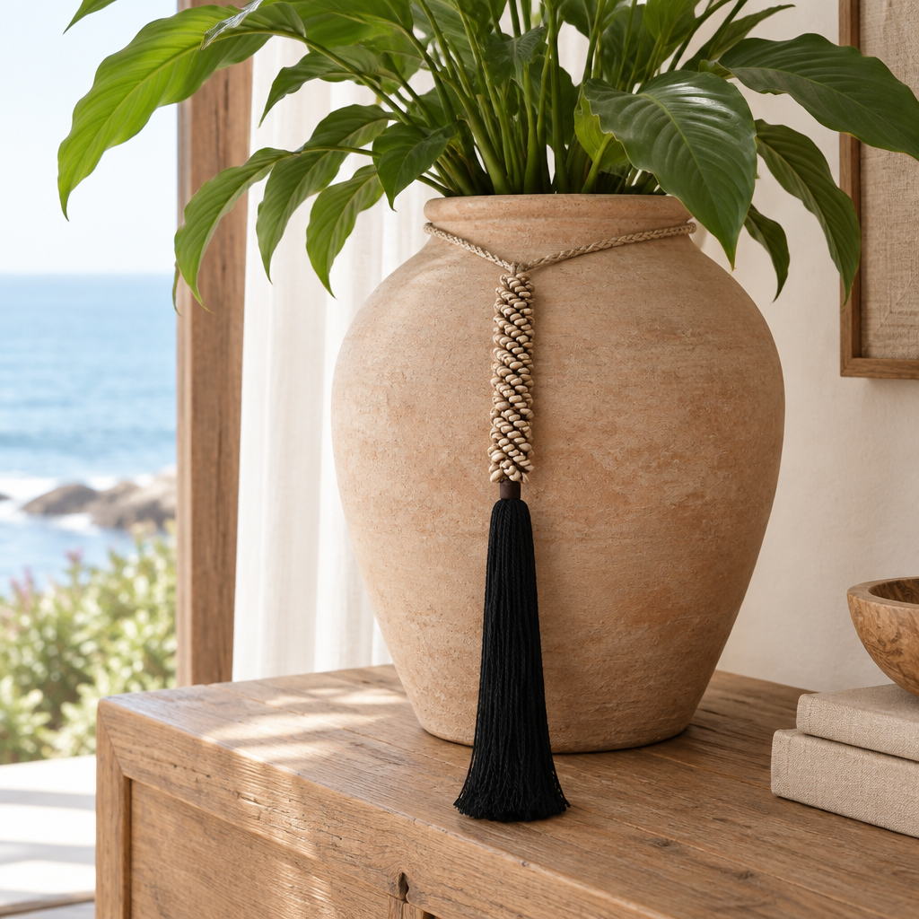 Cream clustered detail and black cotton fringe hanging beside a leafy plant