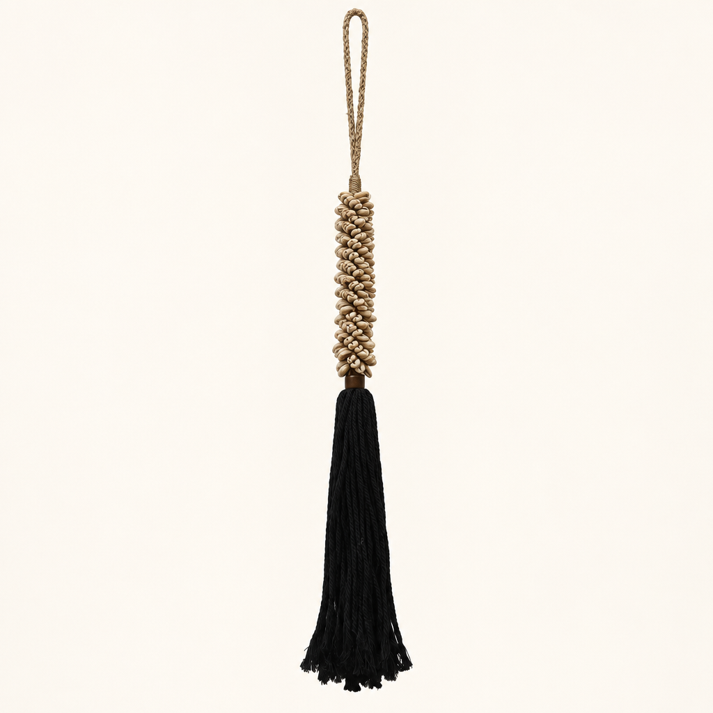 Cowrie shell decorative tassel tieback with black cotton fringe on a light background
