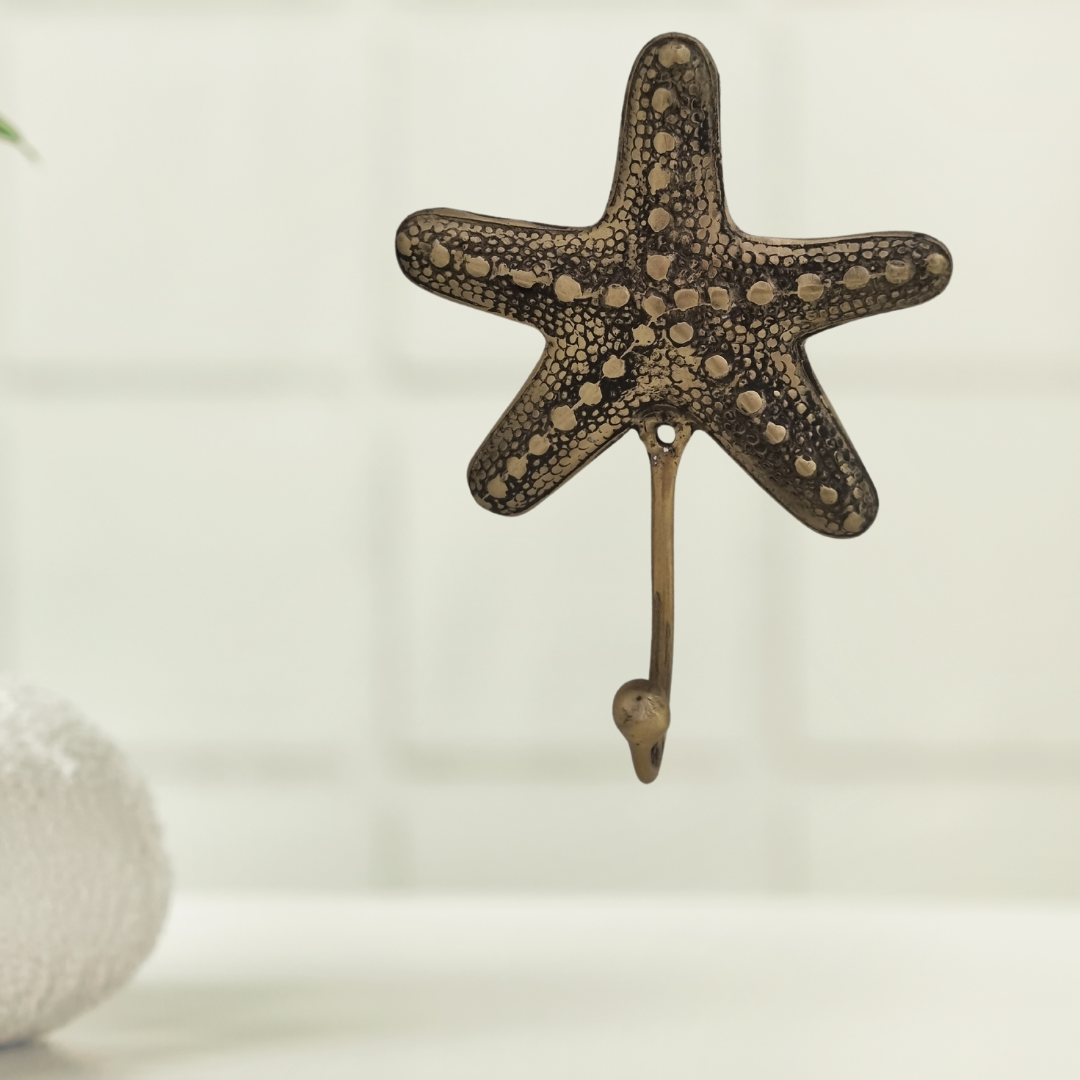 Brass starfish wall hook mounted on white subway tiles in a Hampton-style bathroom interior