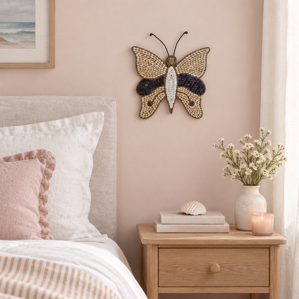 Handmade winged decoration above a timber bedside table in a softly styled pink bedroom