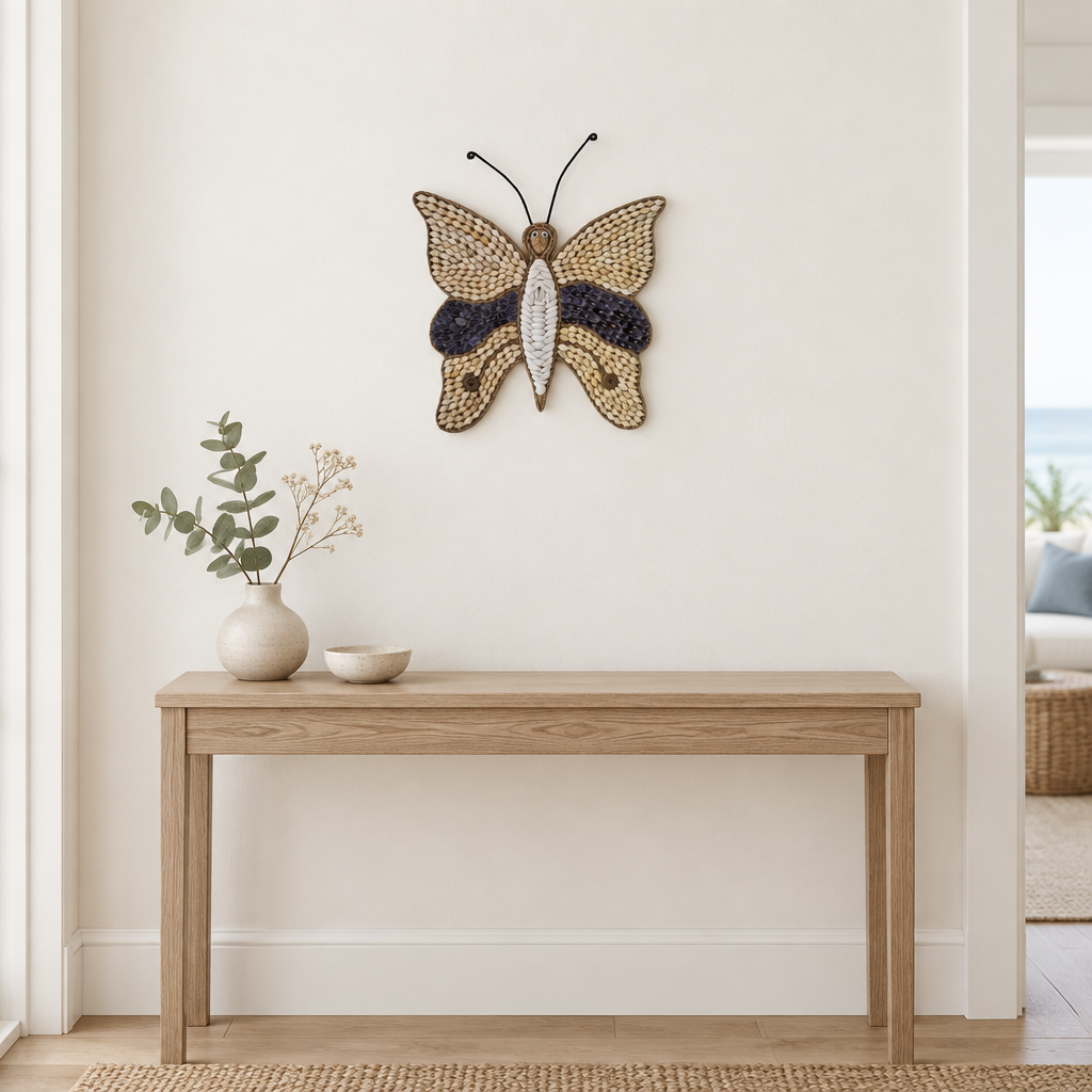 Small winged decoration above a slim timber hallway console with a ceramic vase