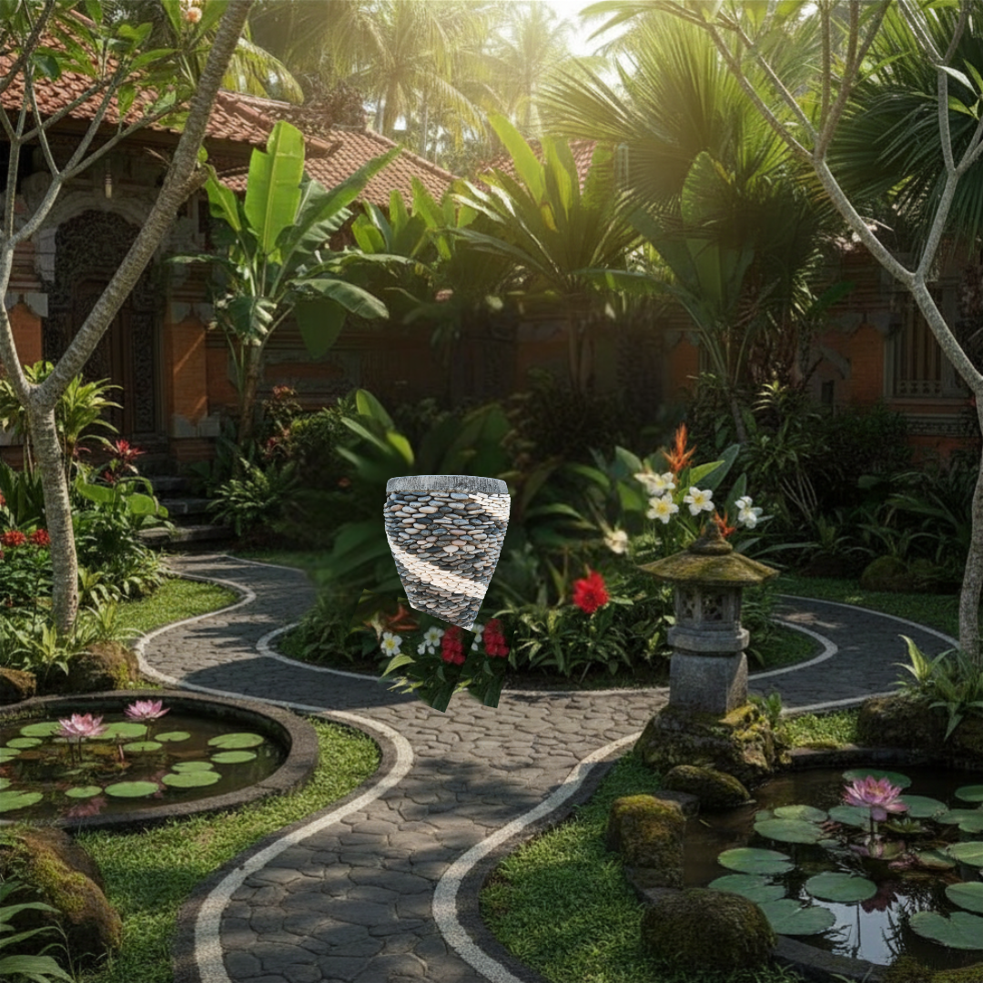 Marble and pebble Balinese style garden pot styled as a garden feature surrounded by colourful flowering plants, agave, a stone pathway, and mulched garden beds