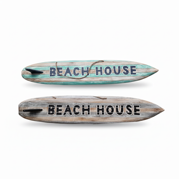 Two rustic surfboard-shaped wall signs reading "BEACH HOUSE" are shown on a white background, one with distressed turquoise and wood stripes, and one with weathered gray and wood stripes.