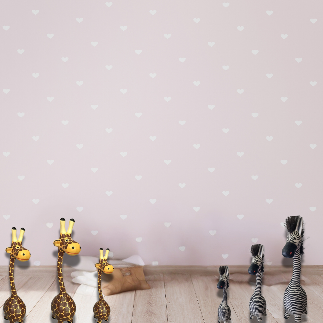 Set of toy giraffes and zebras on a wooden floor with a polka dot wall background