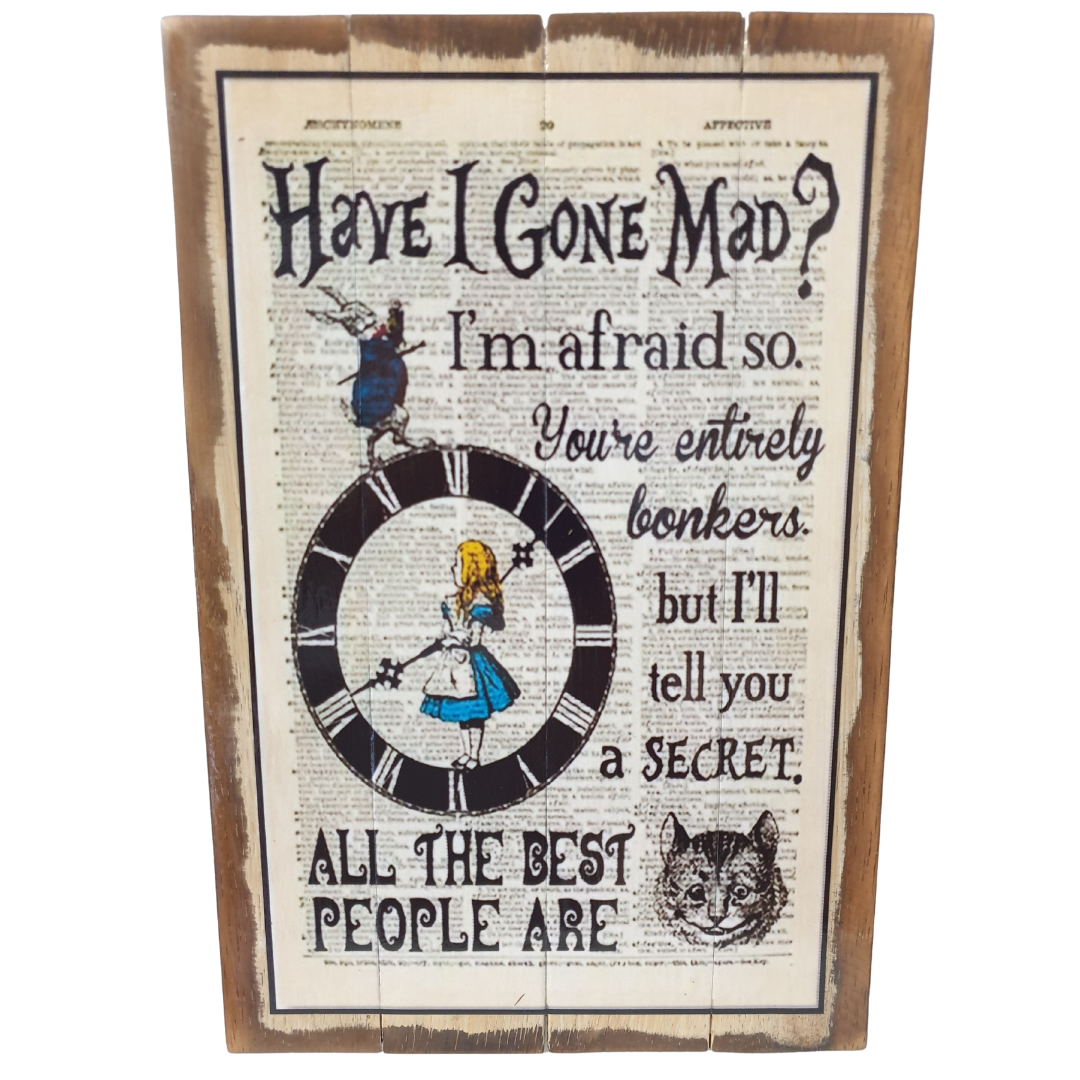 A rustic wooden sign featuring Alice in Wonderland artwork, including the text 'Have I Gone Mad? I'm afraid so. You're entirely bonkers but I'll tell you a SECRET.