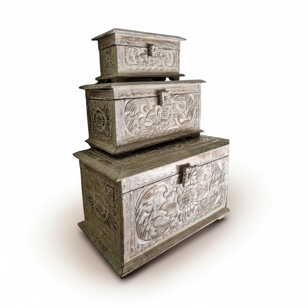 Three stacked Balinese-style carved wooden storage boxes with a distressed whitewash finish.