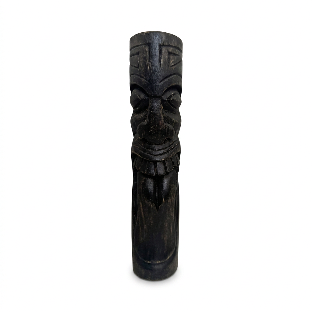 Dark timber carving with rounded eyes, a patterned forehead and a long tongue extending below its teeth, standing on a white background
