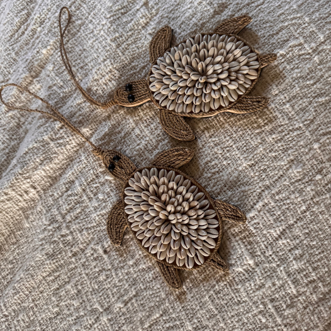 Two turtle-shaped decorative items with textured shells on a textured surface