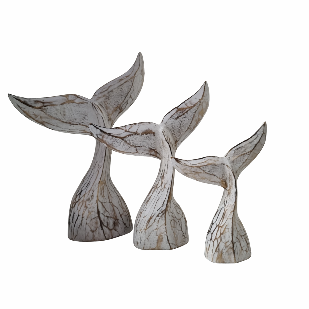 Decorative whale tail sculptures on a white background