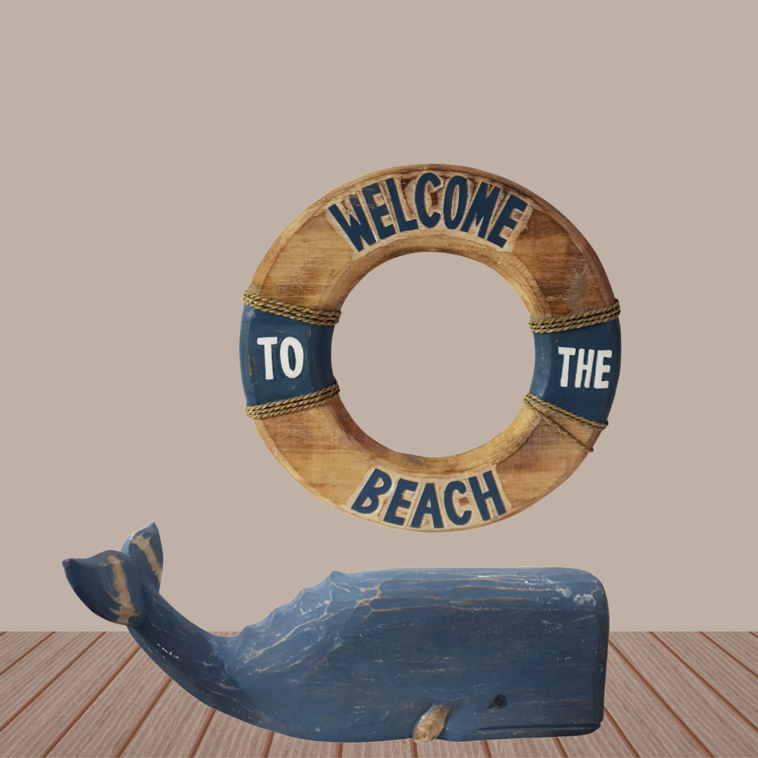 Decorative life buoy with 'Welcome to the Beach' text and a blue whale sculpture on a wooden floor.