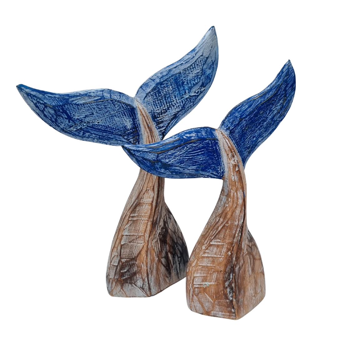 A handcrafted wooden carving of a whale tail with natural wood color and subtle blue hints.