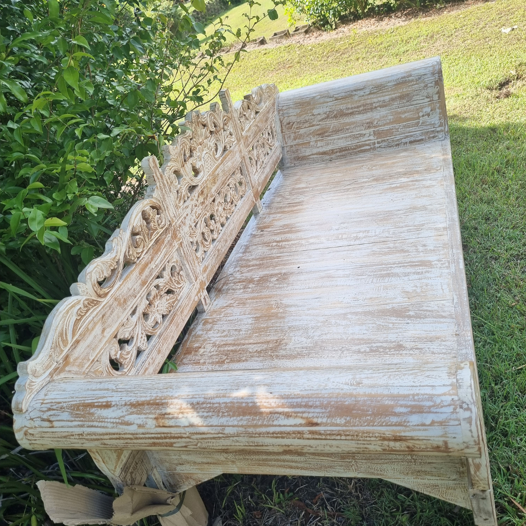 side view on a wooden daybed in a garden setting